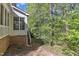 Exterior view of the home's backyard with lush trees, a deck, and a glimpse of the home's exterior at 8012 Glenbrittle Way, Raleigh, NC 27615