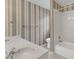 Well-lit bathroom featuring a double sink vanity and tub/shower combo with striped wallpaper at 8012 Glenbrittle Way, Raleigh, NC 27615