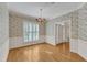 Elegant dining room featuring hardwood floors, floral wallpaper, and bright natural light from shuttered windows at 8012 Glenbrittle Way, Raleigh, NC 27615