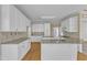 Well-equipped kitchen showcasing granite countertops, white cabinetry, and hardwood floors at 8012 Glenbrittle Way, Raleigh, NC 27615
