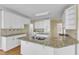 Well-equipped kitchen showcasing granite countertops, white cabinetry, and hardwood floors at 8012 Glenbrittle Way, Raleigh, NC 27615