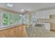 Modern kitchen featuring a large island, granite countertops, and ample natural light from surrounding windows at 8012 Glenbrittle Way, Raleigh, NC 27615