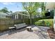 Relaxing backyard space with a pea gravel patio, cozy couch, grill and string lights at 806 Edmund St, Raleigh, NC 27604