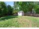 Large backyard with a storage shed, green grass, and a privacy fence, perfect for outdoor enjoyment at 806 Edmund St, Raleigh, NC 27604
