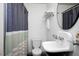 Well-lit bathroom featuring a classic pedestal sink, white tiling, and a stylish shower curtain at 806 Edmund St, Raleigh, NC 27604