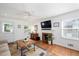 Bright living room boasts a ceiling fan, hardwood floors, fireplace, and ample natural light at 806 Edmund St, Raleigh, NC 27604