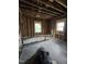 Unfinished room with visible studs, new windows and a large trash bag in the foreground at 827 Sunset Ave, Rocky Mount, NC 27804
