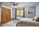 Bedroom featuring hardwood floors, a window, a ceiling fan, and a comfortable bed with decorative pillows at 8407 Millers Bnd, Bahama, NC 27503