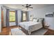 Bedroom with hardwood floors, large windows, a ceiling fan, and a comfortable bed with soft pillows at 8407 Millers Bnd, Bahama, NC 27503