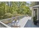 Deck with a table and seating offers a private view of surrounding trees at 8407 Millers Bnd, Bahama, NC 27503