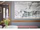 Close-up of a dining area with a large piece of modern artwork hanging on the wall at 8407 Millers Bnd, Bahama, NC 27503