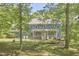 Charming two-story home with covered porch, framed by mature trees and a well-maintained lawn at 8407 Millers Bnd, Bahama, NC 27503