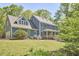 Beautiful two-story home with covered porch and attached garage nestled among mature trees at 8407 Millers Bnd, Bahama, NC 27503