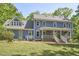 Inviting two-story home featuring classic blue siding, a covered porch, and large windows at 8407 Millers Bnd, Bahama, NC 27503