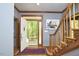 Inviting foyer with an open doorway leading to the outdoors and a staircase with wooden banisters at 8407 Millers Bnd, Bahama, NC 27503