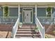 Inviting front porch with brick stairs, white railing, and potted plants adding charm at 8407 Millers Bnd, Bahama, NC 27503