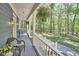 Cozy front porch featuring comfortable seating and serene wooded views at 8407 Millers Bnd, Bahama, NC 27503