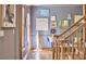 Hallway features grey walls decorated with modern artwork and a staircase with wooden railing at 8407 Millers Bnd, Bahama, NC 27503