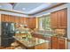 Spacious kitchen features wood cabinets, granite counters, stainless steel appliances, and an island with seating at 8407 Millers Bnd, Bahama, NC 27503
