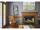 Cozy living room with fireplace, chair, and natural light from deck access at 8407 Millers Bnd, Bahama, NC 27503