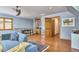 Cozy living area with hardwood floors, blue sofa, built-in shelving, a window and an entry door at 8407 Millers Bnd, Bahama, NC 27503