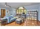 Open-concept living area with hardwood floors, a blue sofa, a large arched window, and built-in shelving at 8407 Millers Bnd, Bahama, NC 27503