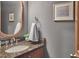 Elegant powder room featuring granite countertop, wood trim, oval mirror, and stylish fixtures at 8407 Millers Bnd, Bahama, NC 27503