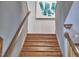 Classic staircase with wooden steps and railing, complemented by neutral walls and artistic decor at 8407 Millers Bnd, Bahama, NC 27503