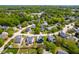 High angle aerial view of suburban neighborhood featuring tree-lined streets and manicured lawns in a residential area at 909 Starkland Way, Holly Springs, NC 27540