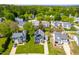 Aerial view of a blue and brick home with a well-kept lawn in a neighborhood with mature trees at 909 Starkland Way, Holly Springs, NC 27540