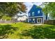 Backyard with a blue house, green grass, some trees, and a patio set at 909 Starkland Way, Holly Springs, NC 27540