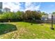 The backyard features lush green grass, a privacy fence, and mature trees at 909 Starkland Way, Holly Springs, NC 27540