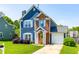 Charming two-story home with blue siding, brick accents, a well-manicured lawn, and a welcoming yellow front door at 909 Starkland Way, Holly Springs, NC 27540