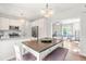 Modern eat-in kitchen featuring white cabinetry, stainless steel appliances, a breakfast bar, and an open layout at 909 Starkland Way, Holly Springs, NC 27540