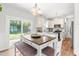 Bright kitchen and dining area with white cabinets, a breakfast bar, modern appliances, and access to the backyard at 909 Starkland Way, Holly Springs, NC 27540