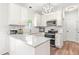 Beautiful kitchen boasts white cabinetry, stainless steel appliances, and marble countertops at 909 Starkland Way, Holly Springs, NC 27540