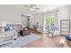 Bright and airy living room with hardwood floors, ceiling fan, stylish furnishings, and large windows at 909 Starkland Way, Holly Springs, NC 27540