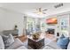 Cozy living room boasts hardwood floors, ceiling fan, a fireplace, and lots of natural light from large windows at 909 Starkland Way, Holly Springs, NC 27540