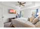 Relaxing main bedroom features a tray ceiling, a TV, and bright windows with blue curtains at 909 Starkland Way, Holly Springs, NC 27540