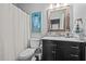 Bathroom with a dark vanity, marble countertop, decorative mirror, and neutral color scheme at 910 S Third St, Mebane, NC 27302