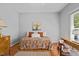 Charming bedroom with hardwood floors, a colorful bedspread, and a classic wooden dresser at 910 S Third St, Mebane, NC 27302
