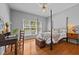 Bedroom with four-poster bed, hardwood floors, and natural light from the windows at 910 S Third St, Mebane, NC 27302