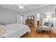 Spacious bedroom featuring hardwood floors, a comfortable bed, and a cozy sitting area at 910 S Third St, Mebane, NC 27302