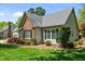 A charming home with a brick chimney, well-kept lawn, and mature trees, offering great curb appeal at 910 S Third St, Mebane, NC 27302