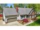Aerial view of a well-maintained home featuring a large roof, attached garage, and mature landscaping at 910 S Third St, Mebane, NC 27302