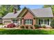 This charming home features a brick facade, complemented by manicured landscaping and a welcoming entrance at 910 S Third St, Mebane, NC 27302