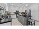 A spacious kitchen with gray cabinetry, black countertops, stainless steel appliances, and a kitchen island at 910 S Third St, Mebane, NC 27302