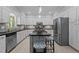 Bright kitchen featuring stainless steel appliances, black countertops and a large island with stools at 910 S Third St, Mebane, NC 27302