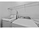 Functional laundry room with a modern washer and dryer, plus storage solutions at 910 S Third St, Mebane, NC 27302