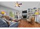 This living room features hardwood floors, a ceiling fan, fireplace and built-in shelves at 910 S Third St, Mebane, NC 27302